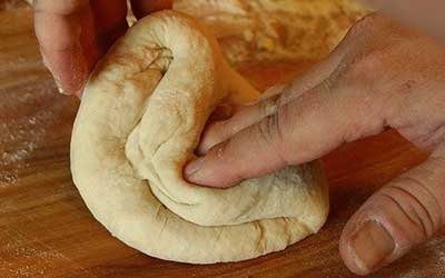 mains robustes pétrissant le pain