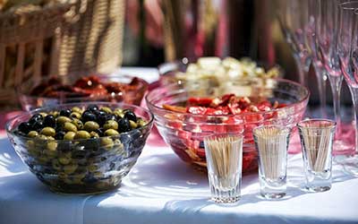 fuentes llenos de olivas y encurtidos sobre una mesa de celebraciones.