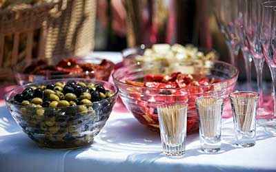 plateaux remplis d'olives et de cornichons sur une table de fête.