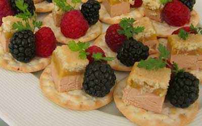 pieces of paté with blackberry and raspberry on salted biscuit.