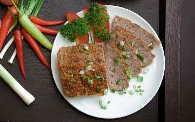 block of pate with vegetables on a plate.