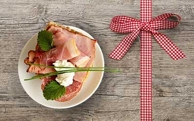 plate with ham next to gift bow with boxes.